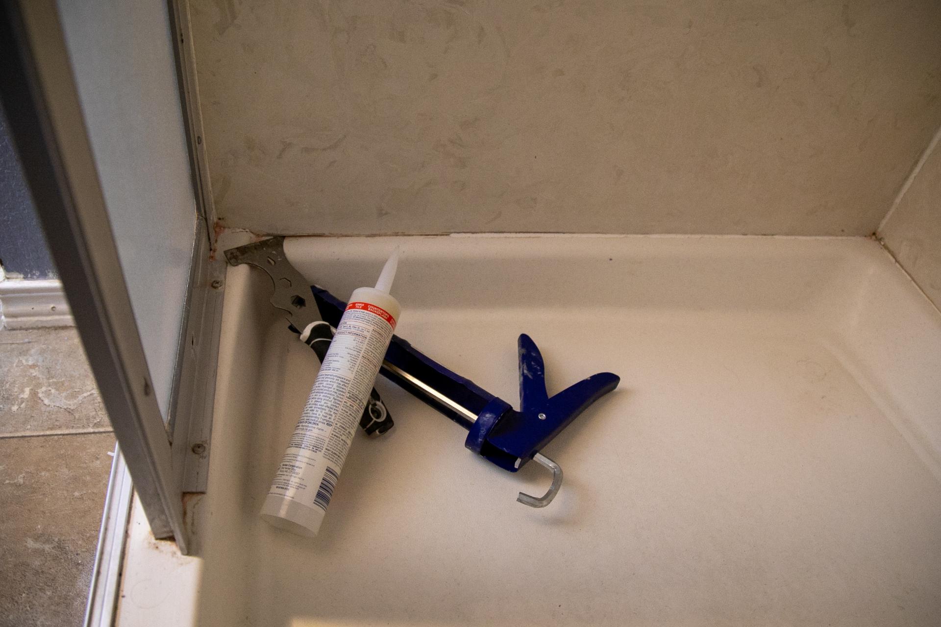Caulking tools on shower floor.