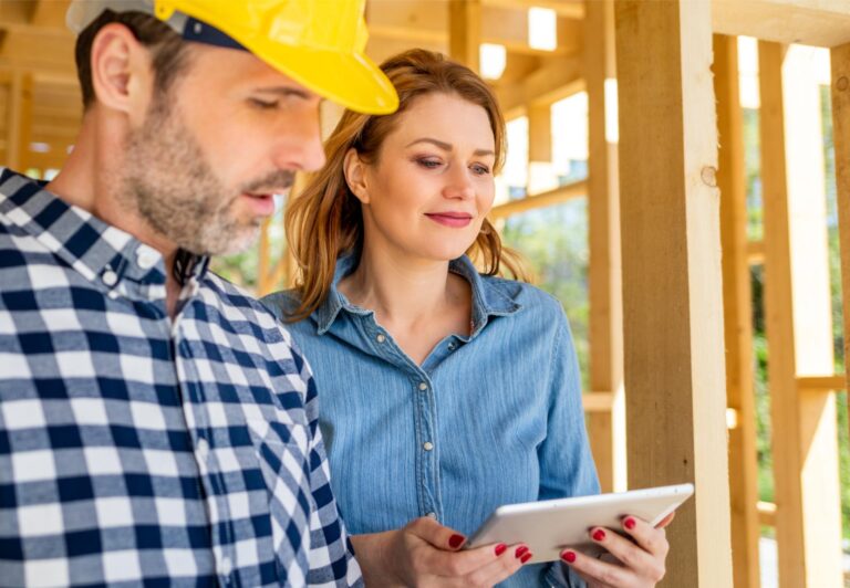 with blueprints meeting with owner of building house on construction site